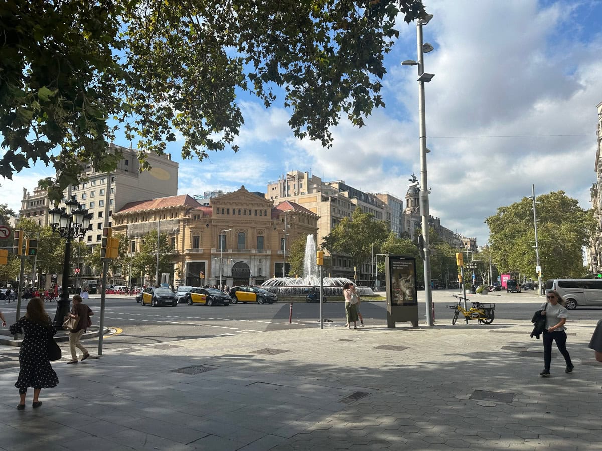 Barcelona, Spain with buildings, cars, intersection, and people walking.