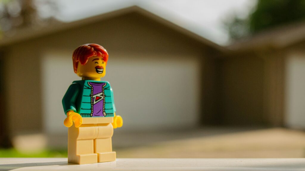 Lego person looking out in front of a blurred property in the background