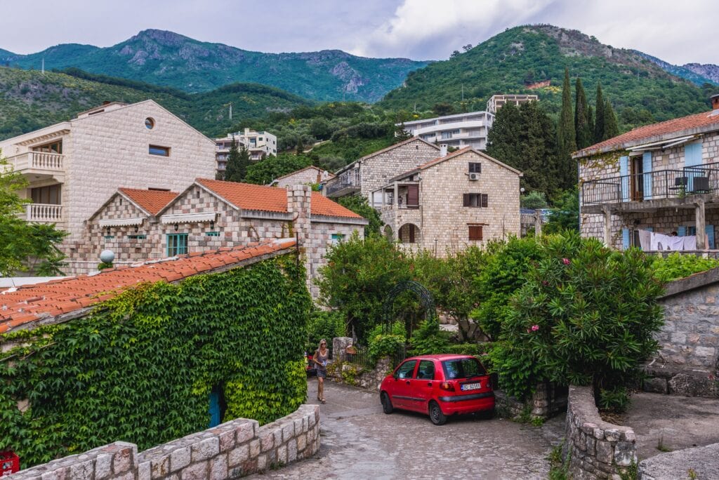 Cute street in a Village in Montenegro with beautiful houses with view of mountains in the distance
