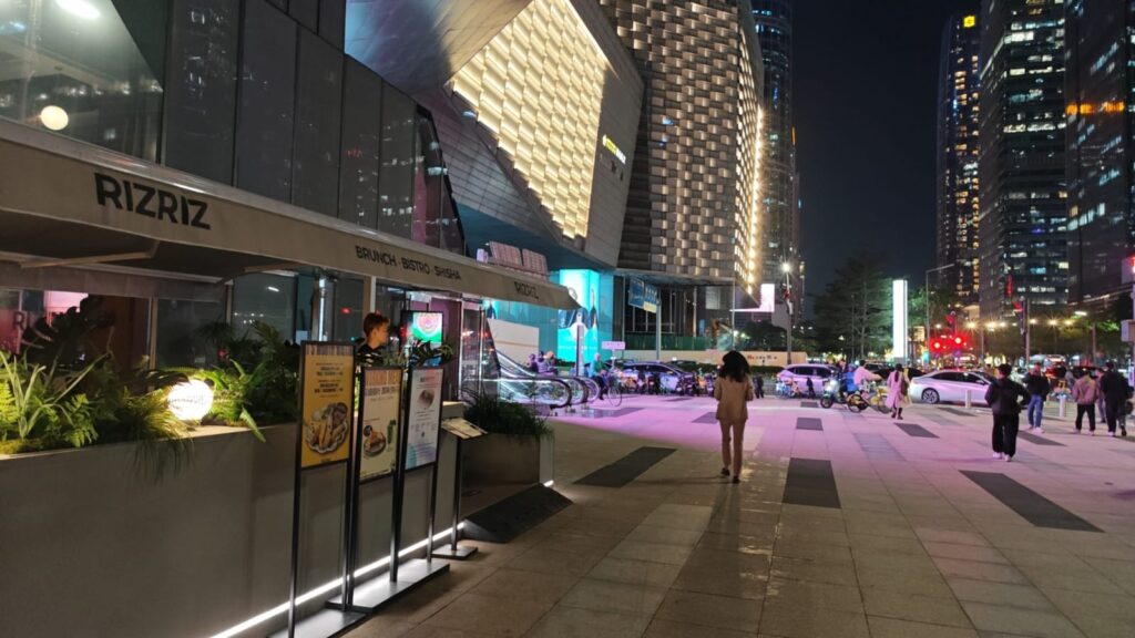 Downtown street in Shenzhen, China, with office buildings and restaurants and shops