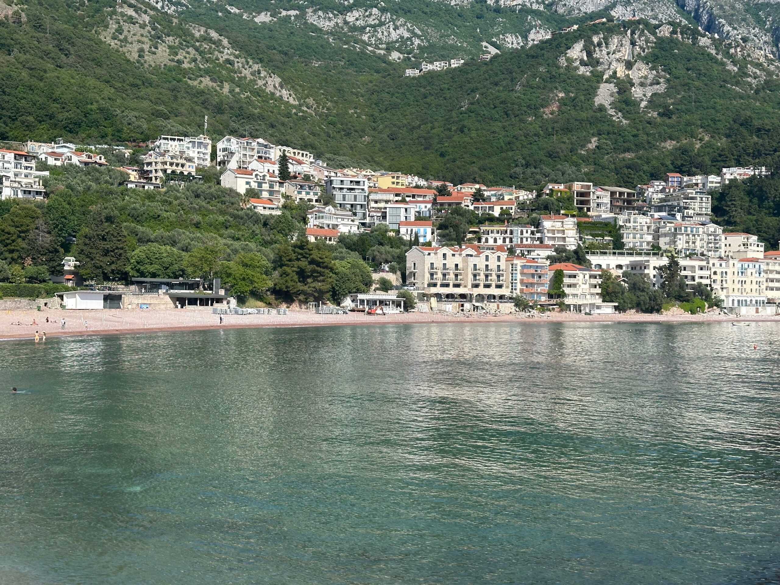 Residential blocks of flats on the coast of Sveti Stefan in Montenegro with a backdrop of mountains