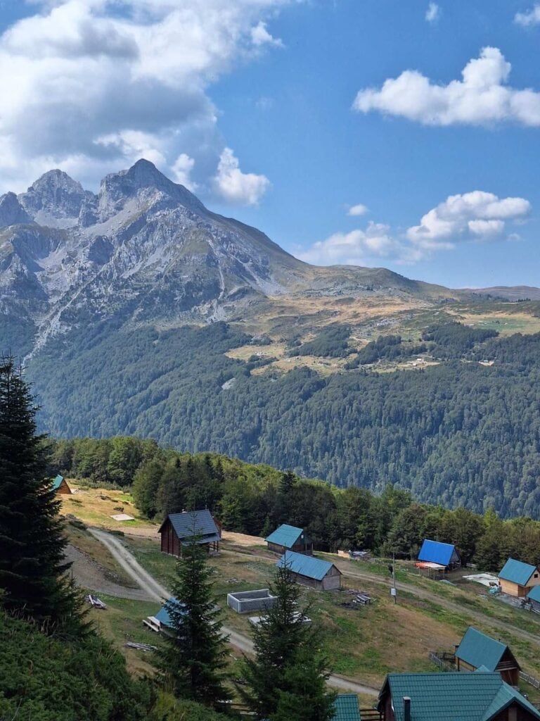 Houses scattered around in rural town in Montenegro with a backdrop of dramatic high mountains