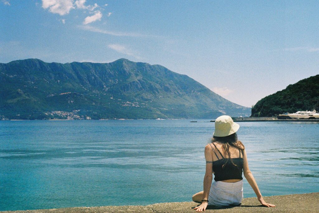 Lady relaxing at the seaside with a backdrop of mountains in Budva, Montenegro