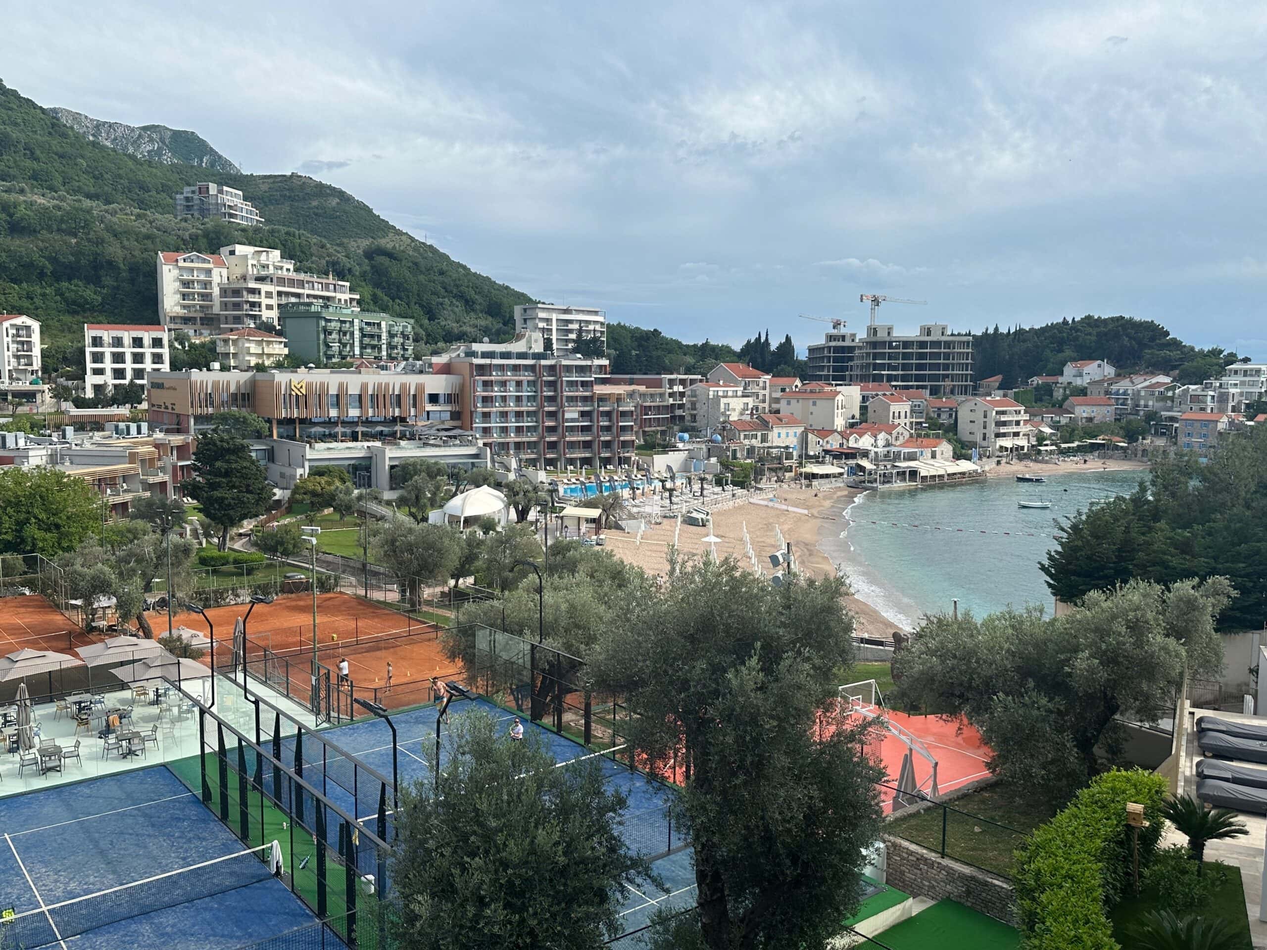 A view of tennis courts and residential blocks of flats on the coast near Budva in Montenegro with a backdrop of mountains