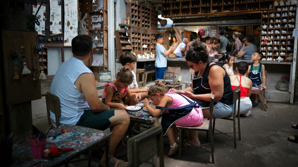 Several families doing arts and crafts - painting and decorating - in a cafe in Chiang Mai, Thailand