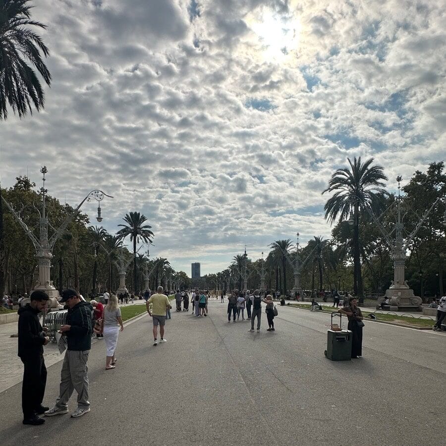 A wide pedestrian promenade of Passeig de Lluís Companys leading to a park in Barcelona, Spain.